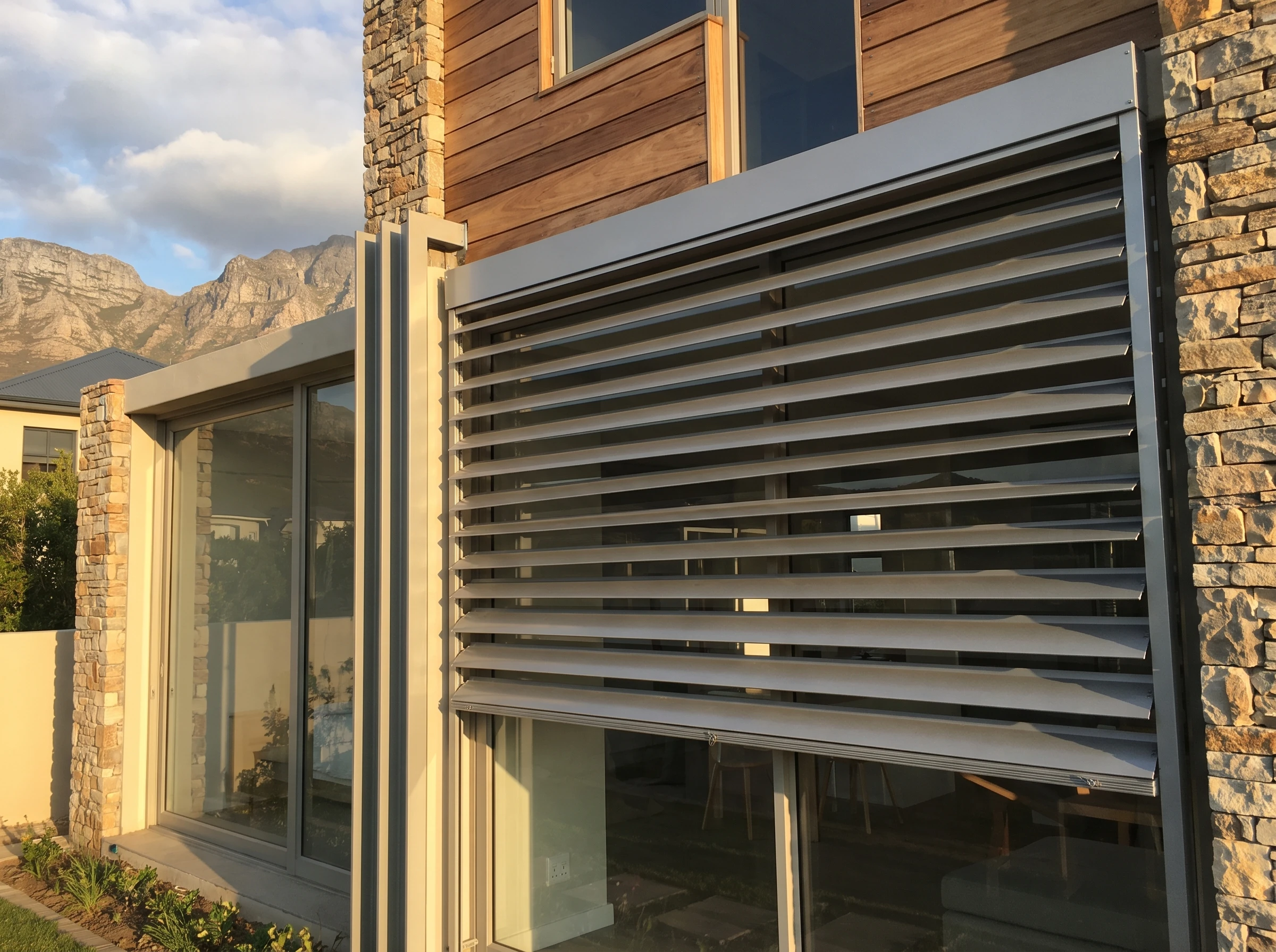 Wide aluminium external venetian blind slats mounted outside a window on a Somerset West Helderberg home with mountains behind